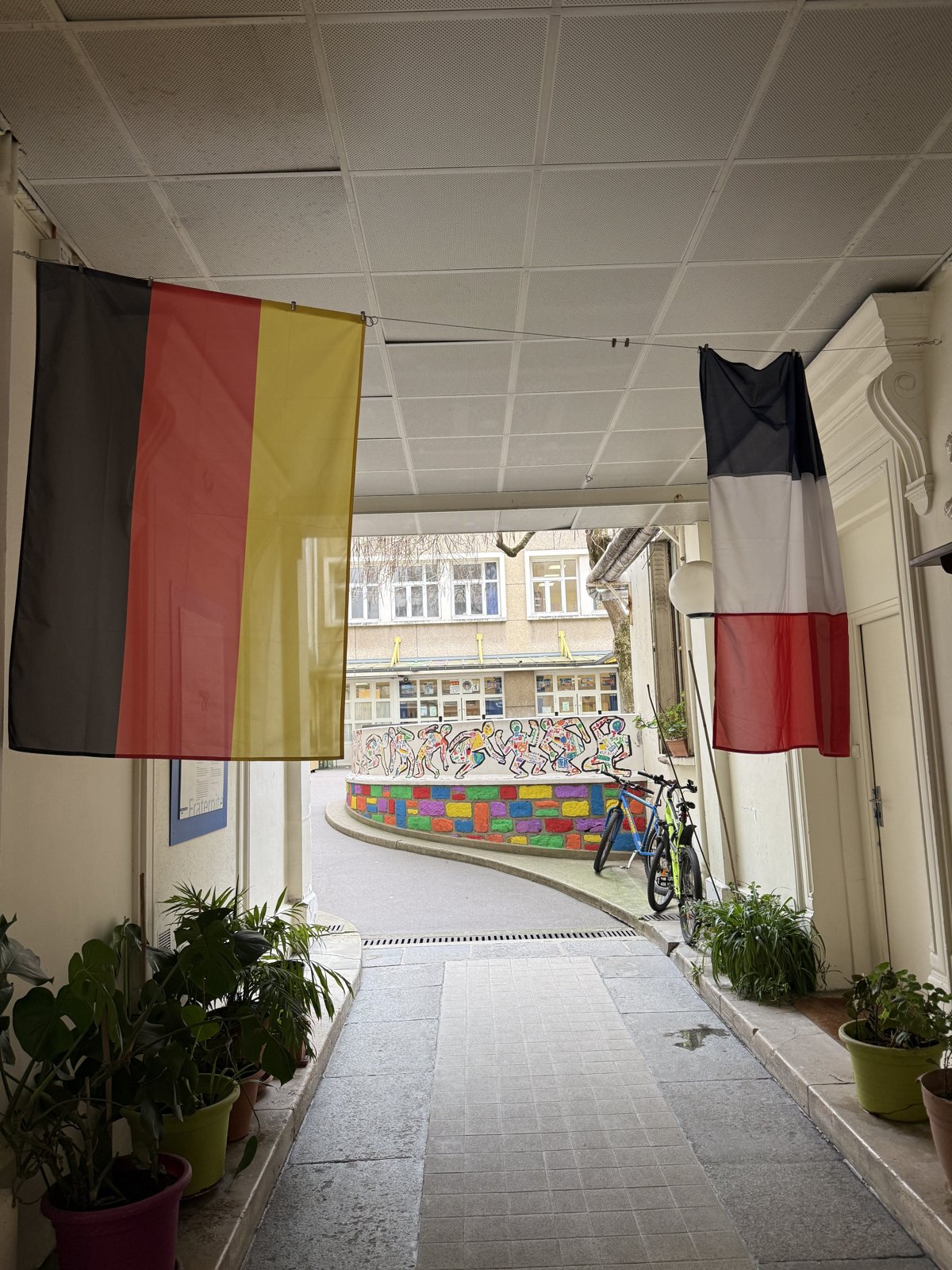 Vue sur la cour de l’école La Fayette, entre les drapeaux allemand et français
